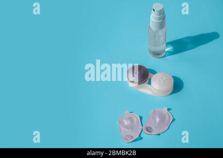 Dinge zum Austauschen und Aufbewahren von Kontaktlinsen. Im Rahmen, Händedesinfektionsmittel, ein Behälter für Linsen und Blasen mit Linsen. Der Hintergrund col Stockfoto