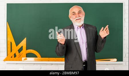 Prozess für jede Lösung. Bärtiger Dozent Mann erklären Geometrie. Zurück zur Schule. Mathematische grafische Werkzeuge. trigonometrie Lektion im Klassenzimmer. Holen Sie sich Wissen hier. Senior Mann Lehrer verwenden mathematische Werkzeuge. Stockfoto