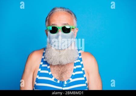 Nahaufnahme Porträt von attraktiven funky froh grau behaart alten Mann verbringen Freizeit Pool Party trotz Quarantäne verwenden schützende medizinische Gesichtsmaske Stockfoto