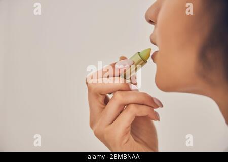 Dunkelhaarige Frau mit einer natürlichen Lippe Feuchtigkeitscreme Stockfoto