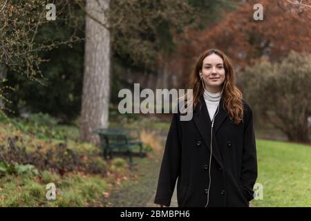 Junge Frau mit ehrlichen Lächeln im Herbst Park Stockfoto