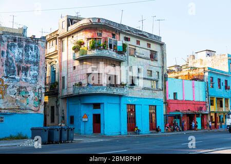 Havanna, Kuba - 25. Juli 2018: Kubaner hängen im Schatten vor ihren alten, bunten und verfallenden Gebäuden, die ihre Häuser sind. Stockfoto