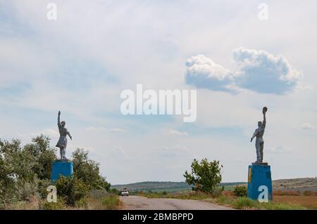 Silhouetten von Arbeiter und Kolchose Frau Stil Statuen an Straßenrändern. Sozialrealismus Denkmäler in der Landschaft der Ukraine Stockfoto