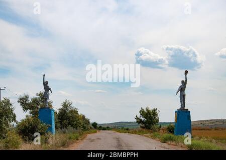 Silhouetten von Arbeiter und Kolchose Frau Stil Statuen an Straßenrändern. Sozialrealismus Denkmäler in der Landschaft der Ukraine. Stockfoto