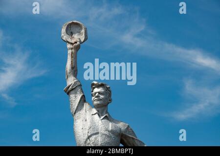 Nahaufnahme der alten verfallenen Steinstatue des sowjetischen tapferen Arbeiters. Sozialrealismus Denkmal in Odessa Landschaft der Ukraine. Denkmal Stockfoto