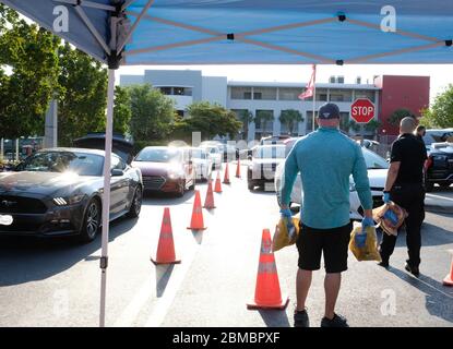 Hialeah Gardens, Usa. Mai 2020. Fahrzeuge stehen für eine Drive-Thru-Verteilung von Lebensmitteln bereit, die von der Master Academy Charter Middle/High School gesponsert wird, um die Bewohner von Hialeah Gardens während der COVID-19-Pandemie in Florida am Freitag, 8. Mai 2020, zu ernähren. Die Verteilung auf die ersten 500 Fahrzeuge begann um 8 Uhr morgens und um 8:30 Uhr wurden fast 240 Fahrzeuge gewartet. Foto von Gary I Rothstein/UPI Quelle: UPI/Alamy Live News Stockfoto