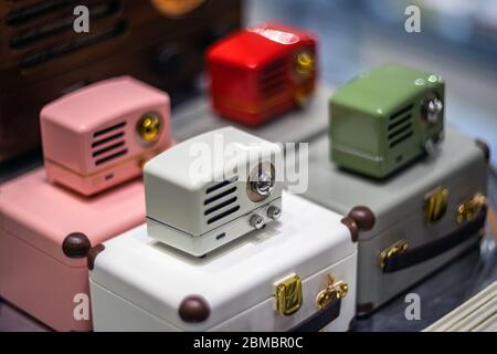 SHANGHAI, CHINA – 28. NOVEMBER 2018. Retro-Filmfoto mit verschwommenem Hintergrund. Vintage-Stil kleine Radio sind in einem Geschenkeladen. Moderne Lautsprecher mit stilisiertem Design Stockfoto