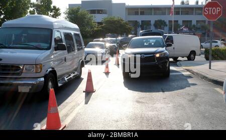 Hialeah Gardens, Usa. Mai 2020. Fahrzeuge stehen für eine Drive-Thru-Verteilung von Lebensmitteln bereit, die von der Master Academy Charter Middle/High School gesponsert wird, um die Bewohner von Hialeah Gardens während der COVID-19-Pandemie in Florida am Freitag, 8. Mai 2020, zu ernähren. Die Verteilung auf die ersten 500 Fahrzeuge begann um 8 Uhr morgens und um 8:30 Uhr wurden fast 240 Fahrzeuge gewartet. Foto von Gary I Rothstein/UPI Quelle: UPI/Alamy Live News Stockfoto