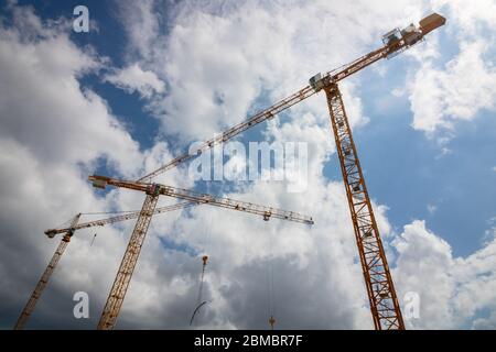 Drei Kraniche auf der Baustelle mit bewölktem Himmel Stockfoto