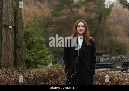 Junge kaukasische Frau posiert im Herbstpark Stockfoto