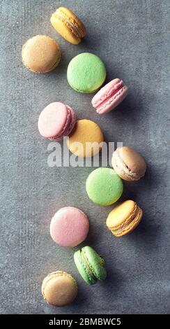 Bunte Macarons auf grauem Marmorgrund. Draufsicht. Pastellfarben Stockfoto