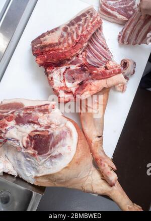 Ganze Tierstücke von Schweinefleisch liegen auf dem Metzgertisch Auf einem Markt Stockfoto