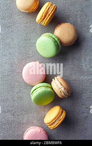 Bunte Macarons auf grauem Marmorgrund. Draufsicht. Pastellfarben Stockfoto