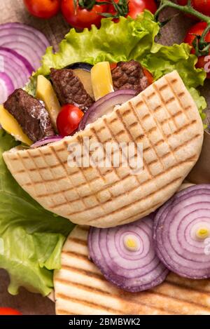 Döner Kebab Pita mit grünem Salat, Tomaten Kirsche, Kartoffel frei, gegrilltes Rindfleisch in der Lunchbox auf Wrap Hintergrund Stockfoto
