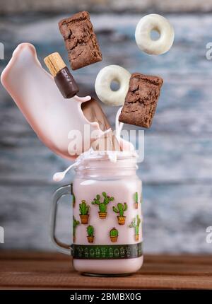 Rosa Erdbeere Freakshake mit Süßigkeiten in der Luft fallen Stockfoto