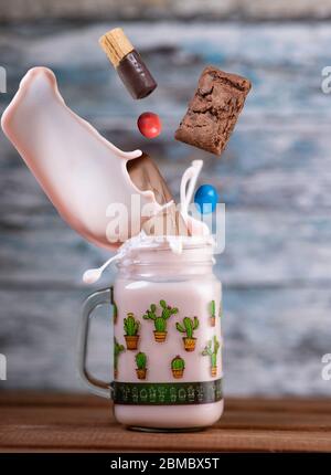 Rosa Erdbeere Freakshake mit Süßigkeiten in der Luft fallen Stockfoto