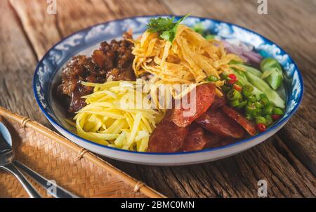 Reis gewürzt mit Garnelenpaste in Thai-Food-Stil Platte auf Holzplatte. Stockfoto