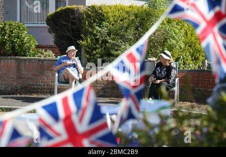 Bournemouth, Großbritannien. Mai 2020. Die Nachbarn Trevor Lelliott und Nina Maynard feiern gemeinsam mit ihren Nachbarn in der Cudnell Avenue, Bournemouth, Dorset, zum 75. Jahrestag des VE Day. Kredit: Richard Crease / Alamy Live News Stockfoto