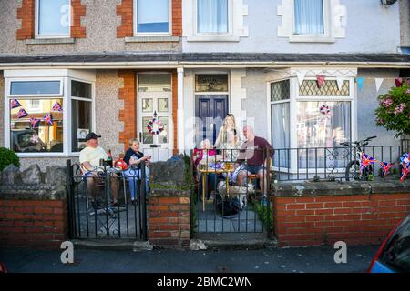 Swansea, Wales, Großbritannien. 8. Mai 2020 die Familien Jones und Williams unterhalten sich mit sozialer Distanz über ihre Mauer in der Cecil Street in Swansea, Wales, während der VE Day Feierlichkeiten. Quelle: Robert Melen/Alamy Live News. Stockfoto