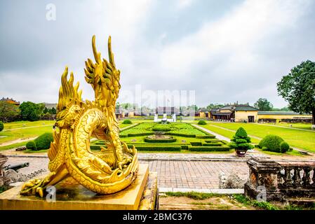 Hue, Vietnam - 15. April 2018: Golddrache mit Blick auf Hue Zitadelle Haupttor mit sehr wenigen Touristen, und einem bewölkten Himmel Stockfoto