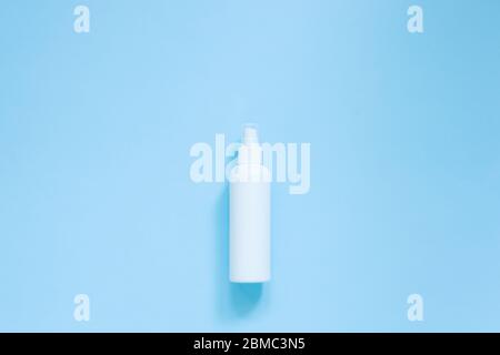 Draufsicht des antibakteriellen antiseptischen Sprays in weißer Flasche für Händedesinfektionsmittel auf blauem Hintergrund. Weiße Sprühspenderpumpe für Kosmetik oder Hygiene Stockfoto