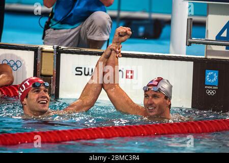 Aaron Peirsol (USA) gewinnt mit dem Silbermedaillengewinner Markus Rogan (AUT) im 200 Meter Rückschlag Finale der Männer beim Olympischen Sommergam 2004 die Goldmedaille Stockfoto