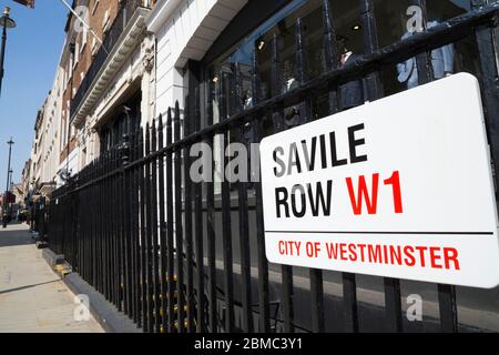 Westminster Straßenschild an der Savile Row in London, die Goldene Meile der Maßanfertigung, ist an den Geländern von Gieves und Hawkes angebracht - Herren Schneider / Schneiderei vor und Fenster Display. GROSSBRITANNIEN (118) Stockfoto