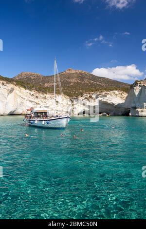 Ein Boot und Menschen schwimmen in Kleftiko, Milos, Kykladen Inseln, Griechenland Stockfoto