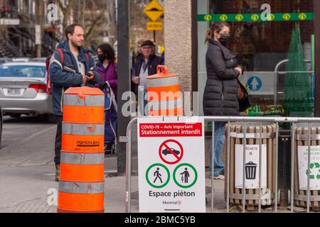 Montreal, CA - 8. Mai 2020 : Kunden in einer Linie außerhalb des Geschäfts. Einige von ihnen tragen Covid-19 Schutzmasken. Stockfoto