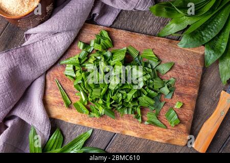 Schneiden Sie frische Rippenwürze Wegerineblätter, um hausgemachten Kräutersirup gegen Husten vorzubereiten Stockfoto