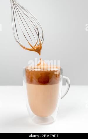 Dal gona Kaffee auf weißem Hintergrund mit Schneebesen und flauschigem Schaum. Stockfoto