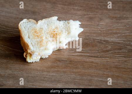 Halb gegessen Sandwich auf den Boden geworfen. Entsorgter Sandwich. Brot auf den Boden geworfen. In den Müll geworfen Lebensmittel. Konzept. Stockfoto