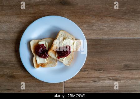 Zwei Scheiben geröstetes Sandwich mit Butter und Himbeer-Marmelade. Frühstück. Draufsicht. Freier Platz für Text. Stockfoto