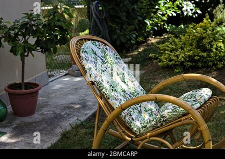 Vintage Schaukelstuhl im Garten mit einem Blumenkissen (Pesaro, Italien, Europa) Stockfoto