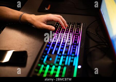 Home Gamer spielt hintergrundbeleuchtete Tastatur Stockfoto