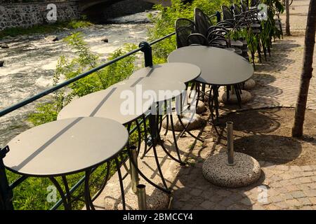 Tische und Stühle eines Restaurants gestapelt und verkettet. Letzte Tage des Aufenthalts zu Hause Ordnung in Meran, Italien. Phase 2 von COVID-19. Stockfoto