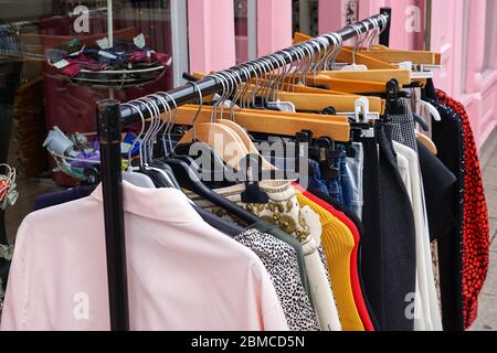 Kleidung hängt vor dem Second Hand Shop Stockfoto