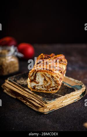 Traditionelle polnische Babka-Torte mit Walnuss. Stillleben von Strudel Brioche oder Walnuss geflochtenem Brot auf dunkel strukturierten Tisch Stockfoto