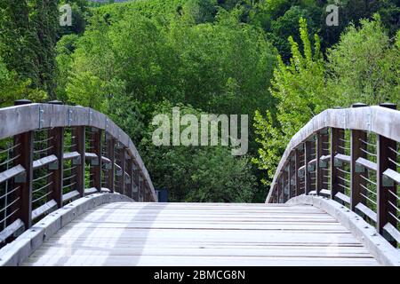 Holzbrücke über die Passer und dahinter Bäume bei Meran, Südtirol, Italien - einfaches Konzept mit Gefühl von Ruhe und Frieden. Stockfoto