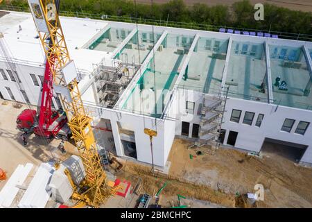 Ein Drohnenfoto einer großen Baustelle, auf der eine große Fabrikhalle gebaut wird Stockfoto