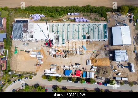 Ein Drohnenfoto einer großen Baustelle, auf der eine große Fabrikhalle gebaut wird Stockfoto