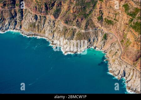 Luftaufnahme der Küste von Hout Bay und der mautpflichtigen Chapman’s Peak Drive Straße, die sich zwischen Noordhoek und Hout Bay an der Atlantikküste windet Stockfoto
