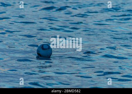 Fußball schwimmend am Meer Stockfoto