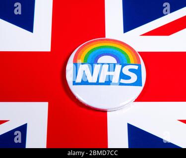 London, Großbritannien - 5. Mai 2020: Ein Pin-Abzeichen mit dem Symbol des National Health Service und Regenbogen, abgebildet über der britischen Flagge. Stockfoto