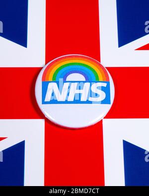 London, Großbritannien - 5. Mai 2020: Ein Pin-Abzeichen mit dem Symbol des National Health Service und Regenbogen, abgebildet über der britischen Flagge. Stockfoto