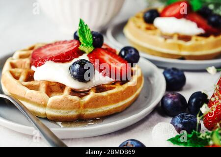 Hausgemachte Mini-Waffeln mit frischen Beeren und Sahne, selektiver Fokus Stockfoto