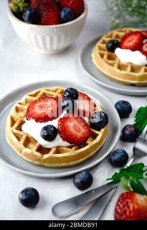 Hausgemachte Mini-Waffeln mit frischen Beeren und Sahne, selektiver Fokus Stockfoto