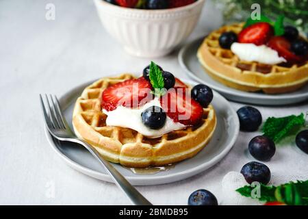 Hausgemachte Mini-Waffeln mit frischen Beeren und Sahne, selektiver Fokus Stockfoto