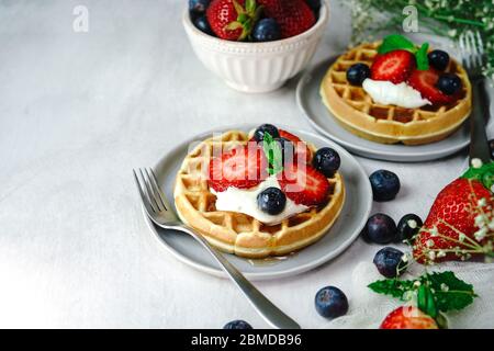 Hausgemachte Mini-Waffeln mit frischen Beeren und Sahne, selektiver Fokus Stockfoto