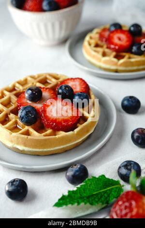 Hausgemachte Mini-Waffeln mit frischen Beeren und Sahne, selektiver Fokus Stockfoto